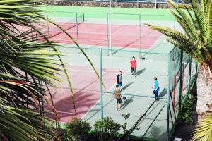 a group of people playing tennis on a tennis court at H10 Suites Lanzarote Gardens in Costa Teguise