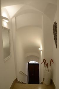 Cuore di Vieste في فييستي: ممر مع باب في غرفة بجدران بيضاء