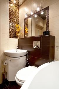 y baño con aseo, lavabo y espejo. en GreenHouse Apartments Komsomolskaya, en Yekaterinburg