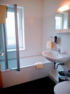 a bathroom with a bath tub and a sink at Excellent Hotel Hamburg in Hamburg +11 photos