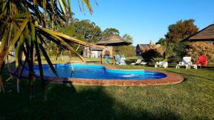 a swimming pool in the middle of a yard at Cabañas Arcángeles de Tandil in Tandil