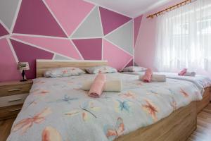 een slaapkamer met een groot bed met roze en paarse muren bij Jasna Crikvenica in Crikvenica