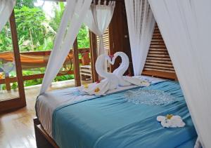 a bed with two swans decorations on it at Lagoona Beach Bungalows - Eco Resort Batukaras in Batukaras