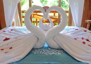 a bed with two swans made out of towels at Lagoona Beach Bungalows - Eco Resort Batukaras in Batukaras