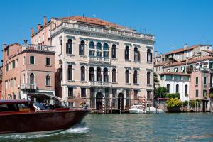 een boot in het water voor gebouwen bij Ca' dei Cuori on the Grand Canal in Venetië