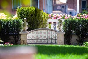 a fence in a garden with statues on it at Ca' dei Cuori on the Grand Canal in Venice