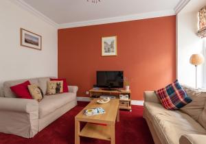 sala de estar con 2 sofás y TV en Blair St Burns apt Old Town en Edimburgo