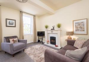- un salon avec un canapé et une cheminée dans l'établissement Castle Suite 3 Old Town, à Édimbourg