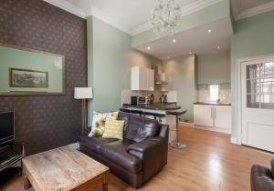 uma sala de estar com um sofá de couro e uma mesa em Bank St Royal Mile em Edimburgo