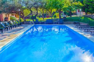 a swimming pool with blue water in a park at Complejo Vip Houses in Merlo
