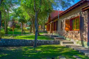 a building with stairs next to a yard with trees at Complejo Vip Houses in Merlo