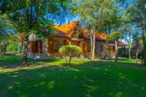 a house in a yard with trees in front of it at Complejo Vip Houses in Merlo