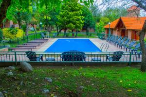 a swimming pool with chairs around it in a park at Complejo Vip Houses in Merlo +21 photos
