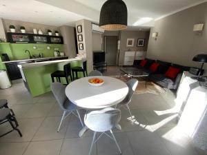 a kitchen and living room with a white table and chairs at Rev'Azur in Fréjus