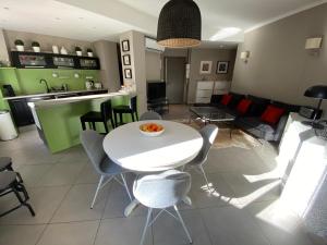 une cuisine et un salon avec une table et des chaises blanches dans l'établissement Rev'Azur, à Fréjus
