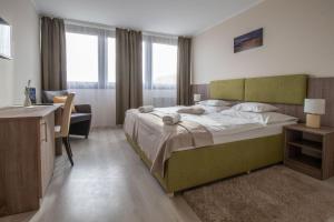 a bedroom with a large bed and a desk at István Király Szálló in Pécsvárad +55 photos
