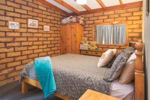 1 dormitorio con cama y pared de ladrillo en Yelverton Brook Conservation Sanctuary, en Metricup