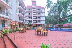 a patio with tables and chairs next to a building at The Horizon in Calangute