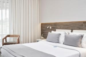 a bedroom with two beds and a wooden headboard at Antigoni Seaside Resort in Ormos Panagias