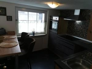 a kitchen with a sink and a table and a window at Fewo Celina in Winterberg