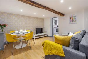 - un salon avec une table et des chaises jaunes dans l'établissement Guest Homes - Bridge Street Residence, à Leominster