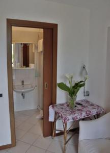 baño con lavabo y mesa con planta en Hotel Ristorante Vittoria, en San Fedele Intelvi