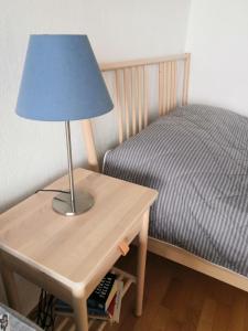 une lampe sur une table à côté d'un lit dans l'établissement Apartment with sauna near the Saimaa lake, à Lappeenranta
