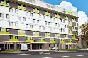 een hotel met een wit en geel gebouw bij B&B HOTEL Paris Meudon Vélizy in Meudon