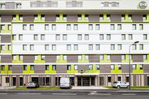 duży budynek z samochodami zaparkowanymi przed nim w obiekcie B&B HOTEL Paris Meudon Vélizy w mieście Meudon