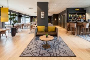 a lobby of a restaurant with a couch and a table at B&B HOTEL Paris Meudon V&eacute;lizy in Meudon