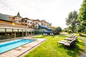 a resort with a swimming pool and a slide at Dolomiten Residenz - Sporthotel Sillian in Sillian