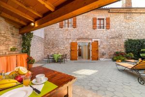 an outdoor patio with a table and chairs and a building at Apartment Malia in Kaštelir