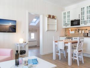 eine Küche und ein Wohnzimmer mit einem Tisch im Zimmer in der Unterkunft Villa Anna - Diamant 08 in Bansin