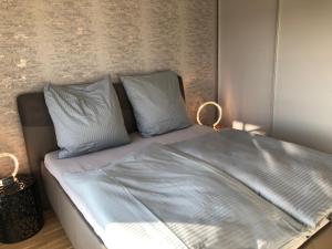 ein Bett mit blauer Bettwäsche und Kissen in einem Schlafzimmer in der Unterkunft Stilvolle Ferien-Geschäftswohnung Brandenburger Seenlandschaft in Werder