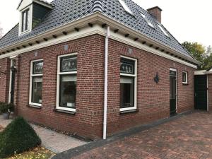 a red brick house with windows and a roof at B&B Oldemarkt in Oldemarkt