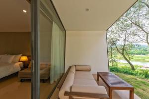 Habitación con sofá, cama y ventana en FLAMINGO DAI LAI RESORT - luxury, en Ngọc Quang