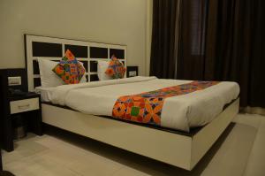 um quarto com uma cama grande e um cobertor colorido em Hotel KK Continental 50 Meter from Railway Station - Amritsar em Amritsar
