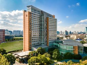 un grand bâtiment avec une ville en arrière-plan dans l'établissement Crowne Plaza Shanghai Fudan, an IHG Hotel, à Shanghai