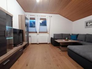 ein Wohnzimmer mit einem Sofa und einem TV in der Unterkunft Ferienwohnung Stiegengraben in Göstling an der Ybbs