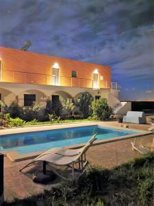 a house with a swimming pool at night at Casa das Portas in Azinhaga