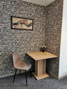 a table and a chair next to a brick wall at Big Apartments in Dortmund