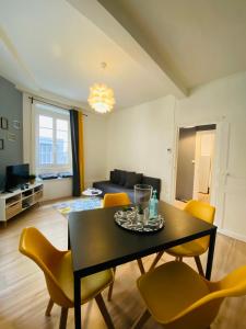 クレルモン・フェランにあるNid Douillet sur plateau centralのリビングルーム(黒いテーブル、黄色の椅子付)