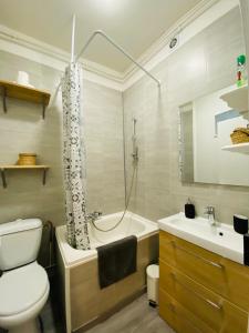 La salle de bains est pourvue d'une baignoire, de toilettes et d'un lavabo. dans l'établissement Nid Douillet sur plateau central, à Clermont-Ferrand