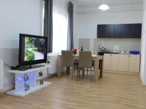 a kitchen and dining room with a table and a television at Apartments Mateo in Zagreb