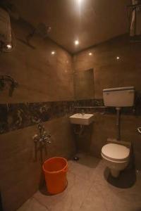 La salle de bains est pourvue de toilettes et d'un lavabo. dans l'établissement Hotel Al Madina palace, à Mumbai