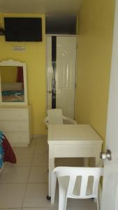 Habitación con escritorio blanco y espejo. en Hotel Victoriano, en San Felipe de Puerto Plata