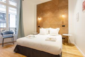 ein Schlafzimmer mit einem großen Bett mit zwei Handtüchern darauf in der Unterkunft CMG-Champs Elysées - Boetie 8 in Paris