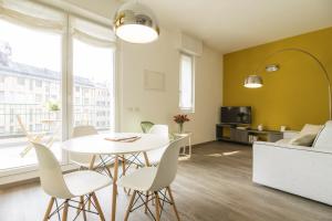 un soggiorno con tavolo, sedie e divano di Contempora Apartments - Cavallotti 13 - A63 a Milano
