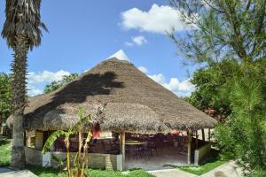 Cabaña con techo de paja, mesas y sillas en Hotel Quinta San Jorge en Tula