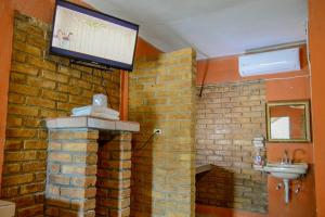 a bathroom with a tv on a brick wall at Hotel Quinta San Jorge in Tula